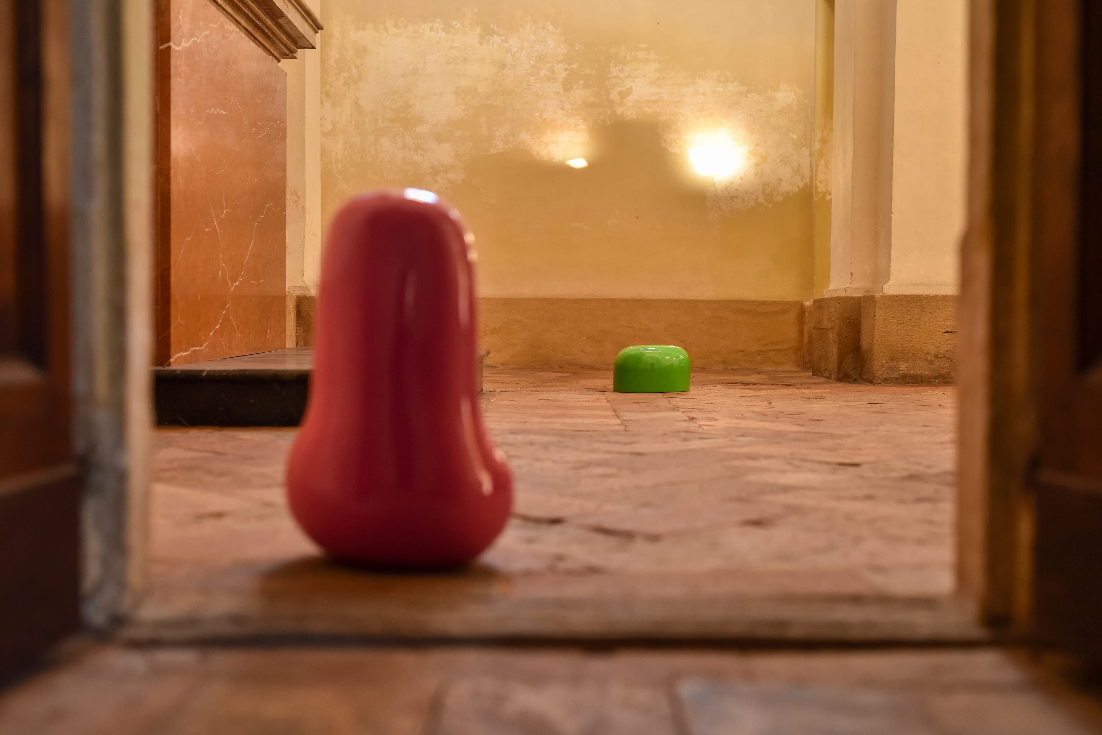 Scultura rossa di Stefano Recanati vista attraverso una porta